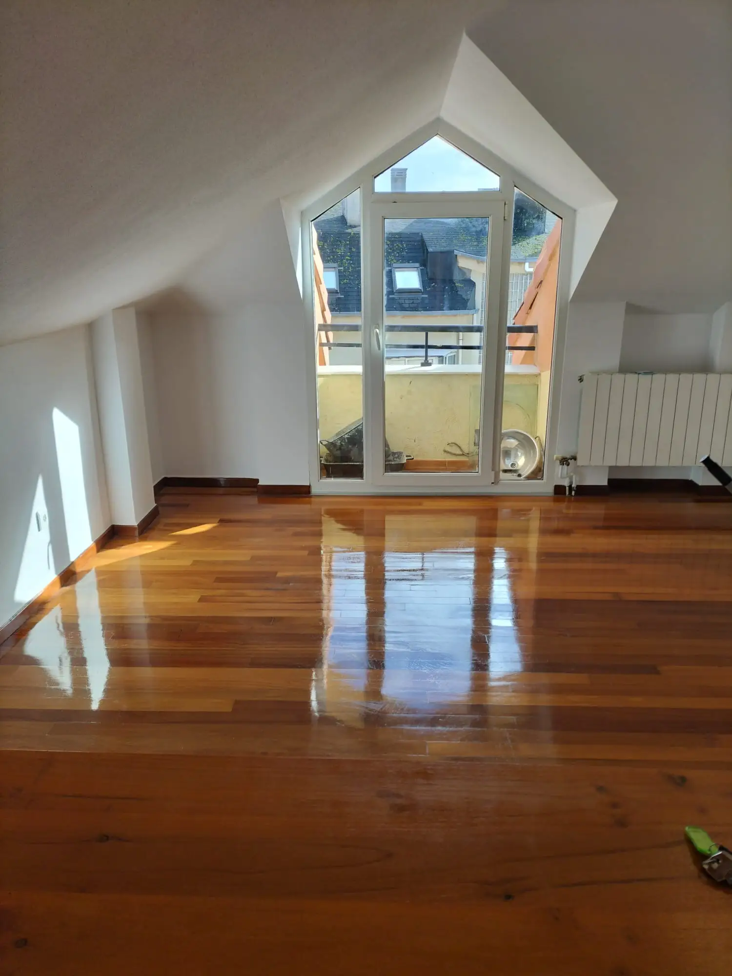 Limpieza de suelo de madera barnizado en buhardilla con ventanal de PVC en Etxebarri
